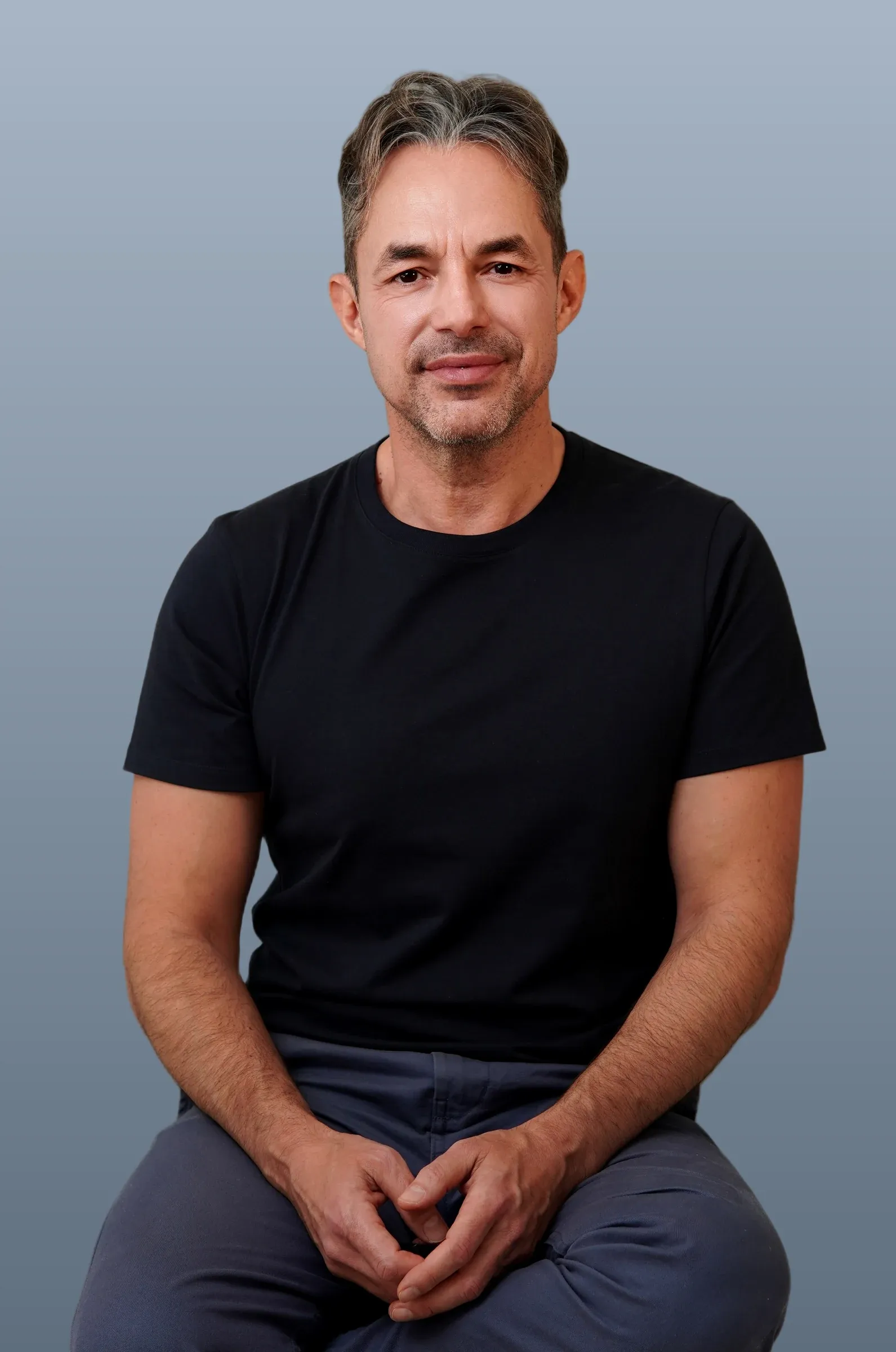 Albin Perigault, assis, jambes croisées.